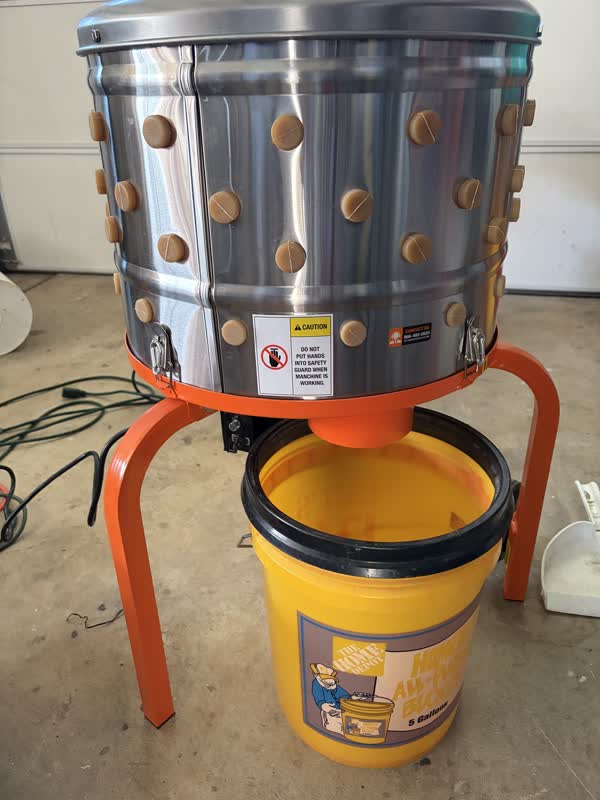 Plucker with a bucket underneath the feather outlet
